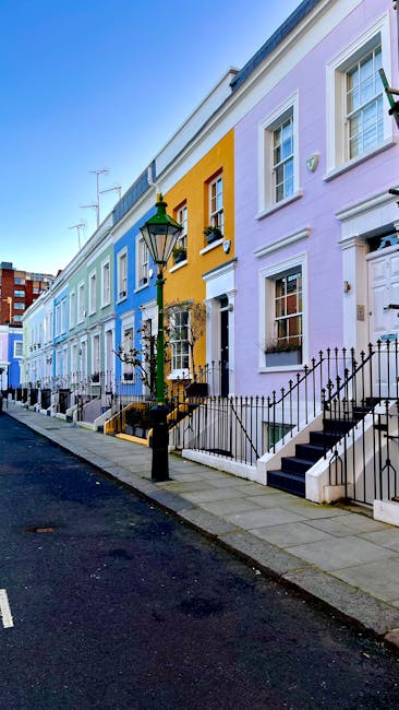 Image of a street scene in South Kensington featuring a row of elegant Victorian-style terraced buildings with cream-colored facades, decorative window trims, and multiple stories. The street is bustl