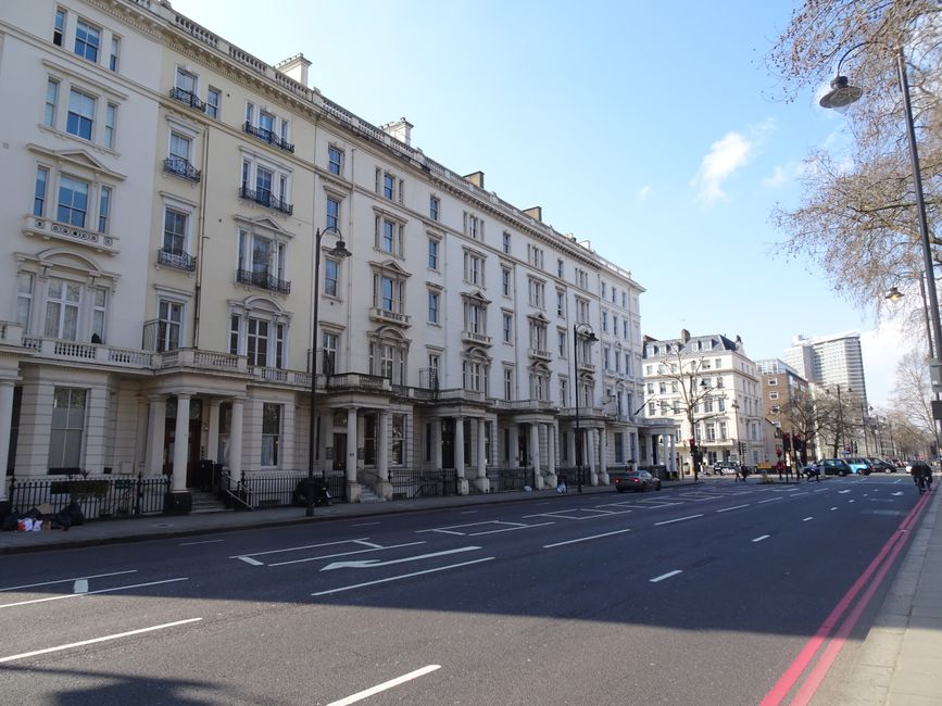 A row of historic white Victorian-style residential buildings in South Kensington with ornate architectural details such as decorative moldings, tall sash windows, and small balconies with black wroug